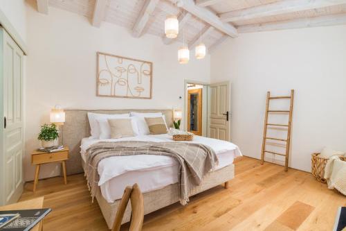 a bedroom with a large bed and a wooden floor at Villa Castello di Papa by Villsy in Veprinac