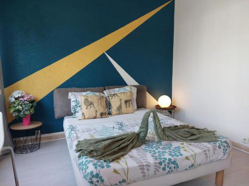 - une chambre dotée d'un lit avec un mur bleu et jaune dans l'établissement Studio Le Trident de la mer - Axelle Loc'Appart, à Cannes