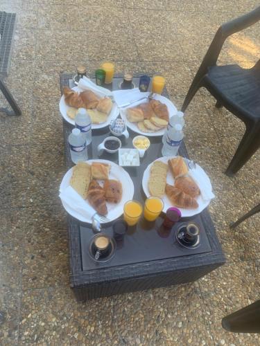 une table avec deux assiettes de nourriture et de jus d'orange dans l'établissement Suite avec sauna, à Pertuis