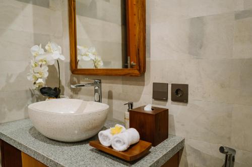 a bathroom with a sink and a mirror and towels at Dream House Ubud in Ubud