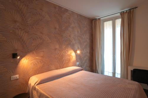 a bedroom with a bed with a patterned wall at NoMad Guest House in La Spezia