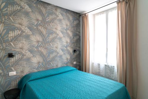 a bedroom with a blue bed with a wall at NoMad Guest House in La Spezia