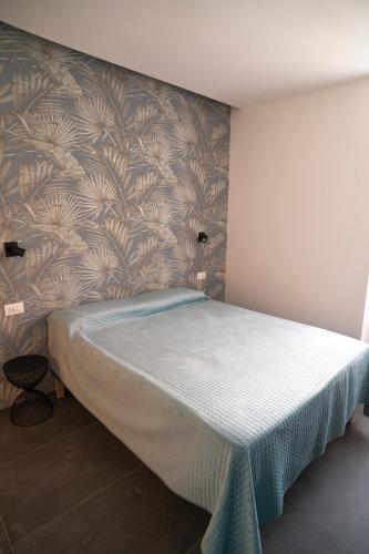 a bedroom with a bed with a wall at NoMad Guest House in La Spezia