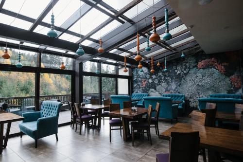 a restaurant with tables and chairs and windows at Goral Hotel & Spa in Bukovel