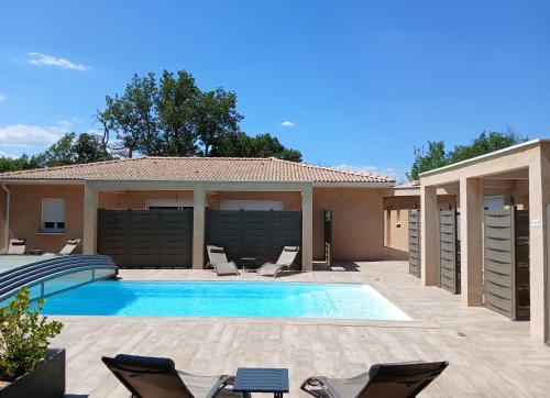 ein Swimmingpool mit Stühlen und ein Haus in der Unterkunft Domaine Chante-Cevennes in Frouzet