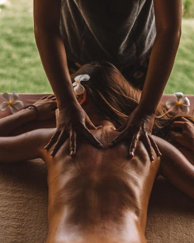 a woman laying on her back while getting a back massage at Sumberkima Hill 3 in Pemuteran