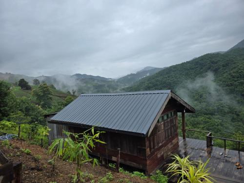 a small building with a view of a mountain at บ้านไร่ไอดอย in Phrae