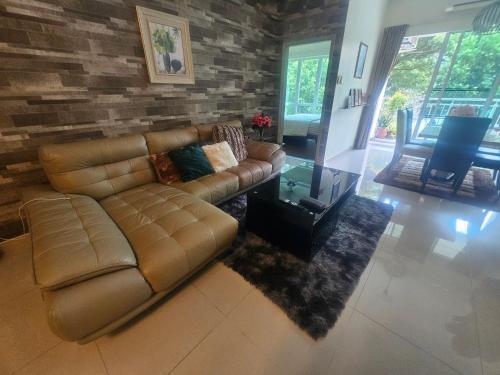 a living room with a couch and a brick wall at Arlyn's Homestay 2 Sandakan in Sandakan