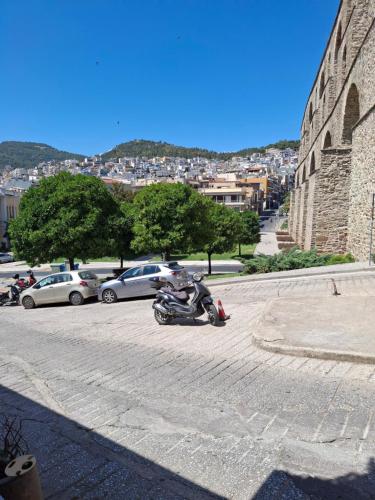 a motorcycle parked in a parking lot next to a building at The Arch Nest in Kavala