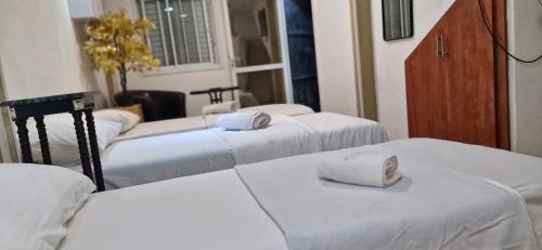 a room with four beds with towels on them at ליאם בכנרת - דירות סטודיו פשוטות נעימות בטבריה in Tiberias