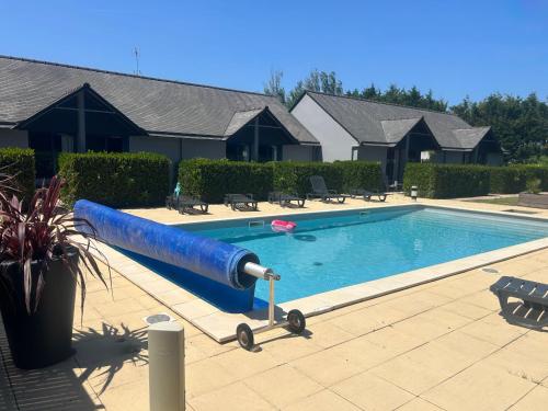 a swimming pool with a blue water slide in a yard at Les Dineux Village in Trémeur