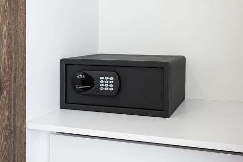 a black microwave oven sitting on a white shelf at Magnolia Apartman in Dunajská Streda