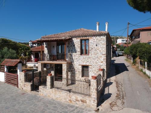 ニキティにあるVilla Stavros Nikiti by BookVillaEUの通りに面したバルコニー付きの小さな石造りの家