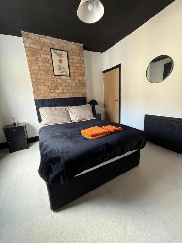 a bedroom with a large bed with a brick wall at Luxury home - Long stays welcome in Grimsby