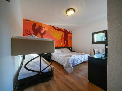 a room with two beds and a desk in it at Hotel Arlecchino - Dada Hotels in Madesimo