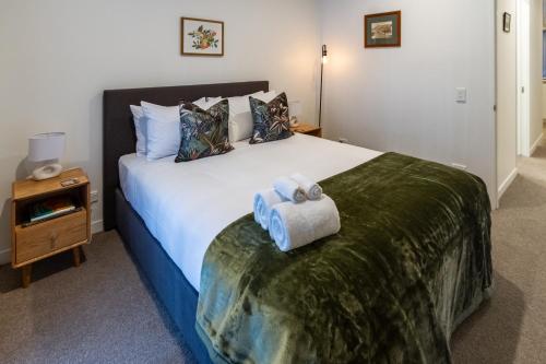 a bedroom with a large bed with two towels on it at Box Office on Madras in Christchurch