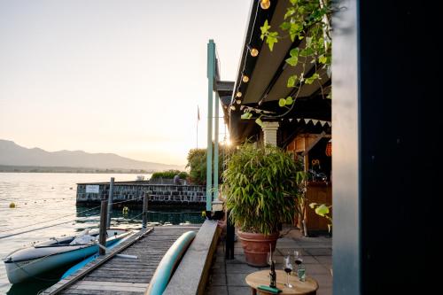 a dock with two boats sitting on the water at Room's at HAUS am SEE direkt am Thunersee gelegen mit SELF CHECK IN & digitaler Rezeption in Oberhofen am Thunersee