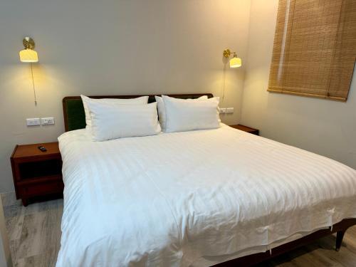 a bedroom with a large bed with white sheets and pillows at 芊禹民宿 - 走路就到鐵花村-微光集-觀光夜市 - in Taitung City