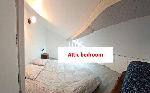 a bedroom with an attic bedroom with a bed at Logement entier dans village calme in Guillerval