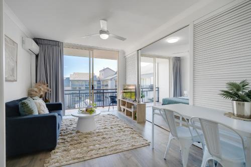 a living room with a table and chairs and a balcony at Limited Time Rate! One Bedroom, Heart of Gold Coast!!! in Gold Coast