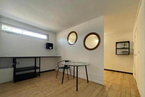 a room with a table and two mirrors on a wall at Coliving Ajaccio in Ajaccio
