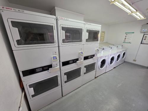 a laundry room with a row of washing machines at Waikiki Vacation Apartment in Honolulu