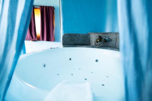 a bath tub in a bathroom with a window at Hotel Alma de Romero in Carranza