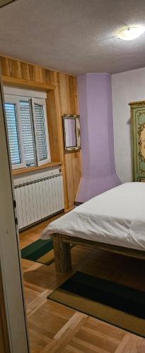 a bedroom with a bed in a room with purple walls at Lazy bear in Doljani