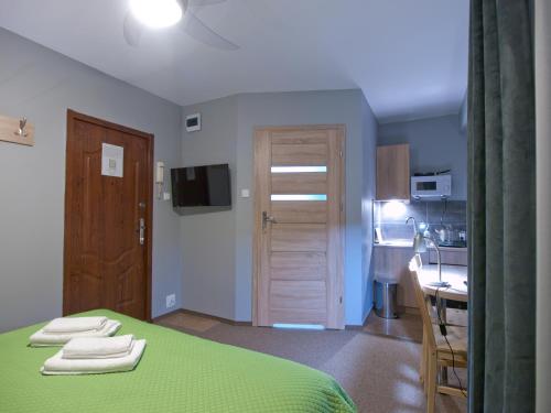 1 dormitorio con 1 cama verde y cocina en Apartamenty studio Metropolio Centrum, en Białystok