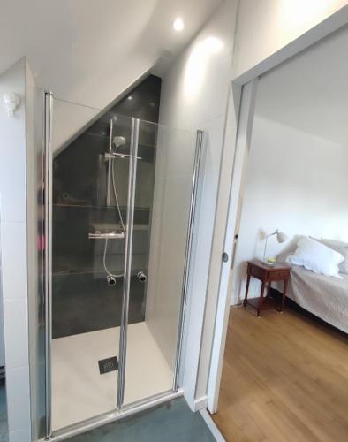 - une douche en verre dans une chambre avec un lit dans l'établissement La Haute Maison - Merrien - GR34 - vue sur mer, à Moëlan-sur-Mer