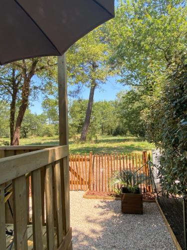a porch with an umbrella and a fence at Cottage Prestige 641 in La Teste-de-Buch