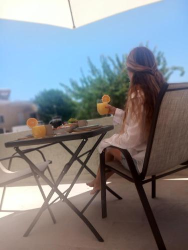 a woman sitting at a table with a plate of food at PAME apartments in Kámpos