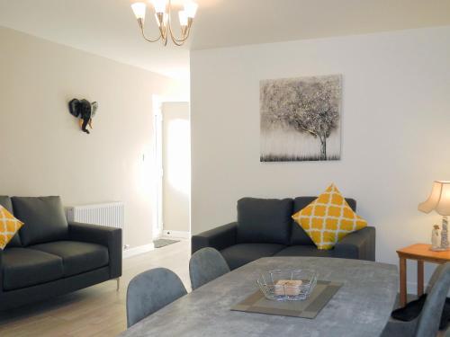 una sala de estar con un sofá y una mesa en East Lodge, en Creebridge