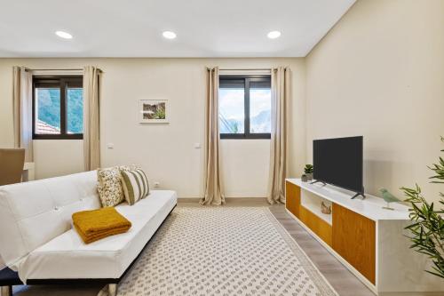 un soggiorno con un divano bianco e una TV di Coração da Madeira by Homie a Curral das Freiras