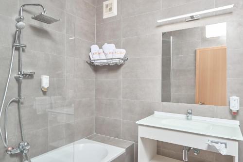 a bathroom with a shower and a sink and a mirror at Thermenhotel Kurz in Lutzmannsburg