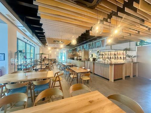 a restaurant with wooden tables and chairs and a bar at Hotel Campus 90 - Free Parking in Varna City