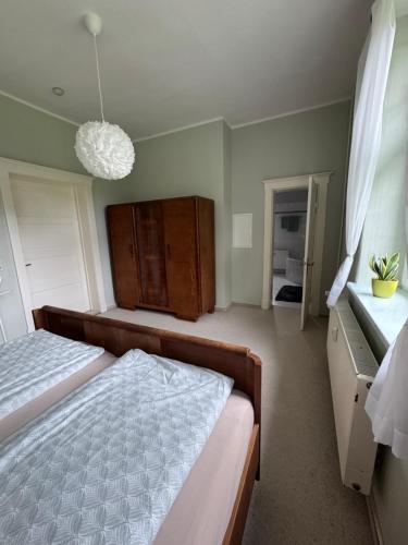 a bedroom with a bed and a chandelier at Landhausvilla Gut Vogelsang in Lalendorf