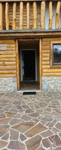 a building with a door with a stone floor at Lazy bear in Doljani