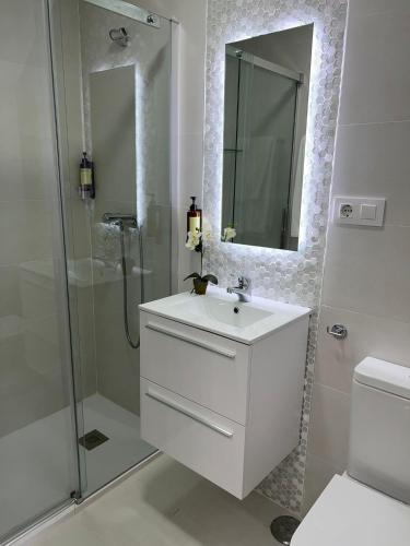 a white bathroom with a sink and a shower at Casa Barrionuevo 2 in La Granja de San Ildefonso