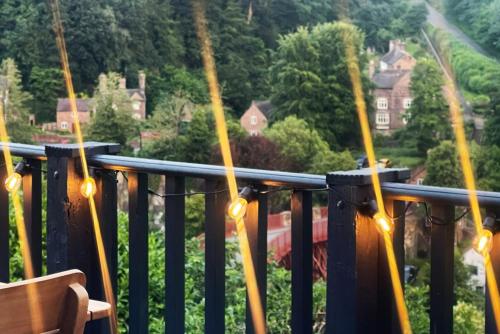a balcony with lights and a view of a house at Ironbridge Tiny Hideaway in Ironbridge