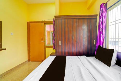 a bedroom with a large bed with purple curtains at Hotel O Heaven Inn in Gwalior