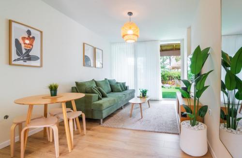 a living room with a green couch and a table at סי מיה - דירות מהממות במתחם נאות גולף in Caesarea