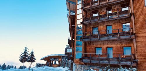 a building with snow on the ground in front of it at Appartement 6 pers Casserousse Les Balcons de Recoin in Chamrousse