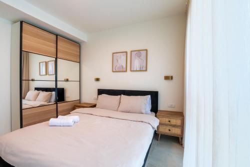 a bedroom with two beds and a mirror at סי מיה - דירות מהממות במתחם נאות גולף in Caesarea