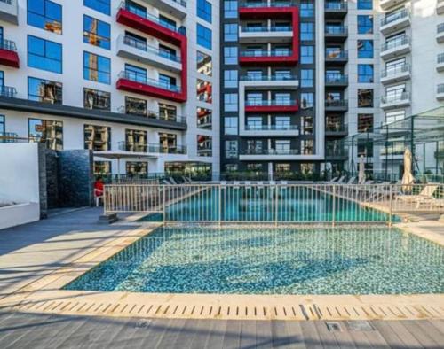 a swimming pool in front of a apartment building at Dubai Arjan Studio - Near Miracle Garden, Hills Mall & Attractions in Dubai