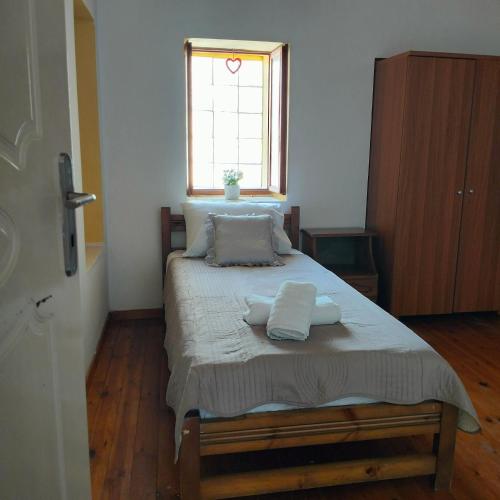 a bedroom with a bed with two towels on it at Agios Dimitrios House in Plomarion
