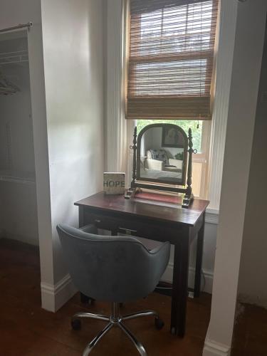 a desk with a mirror and a chair in a room at Dreamers Writing Farm, 3 Wooded Acres, Hepworth in Sauble Beach