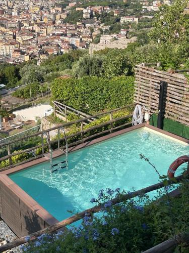 a swimming pool with a chair and a city at Relais Manfredi in Castellammare di Stabia