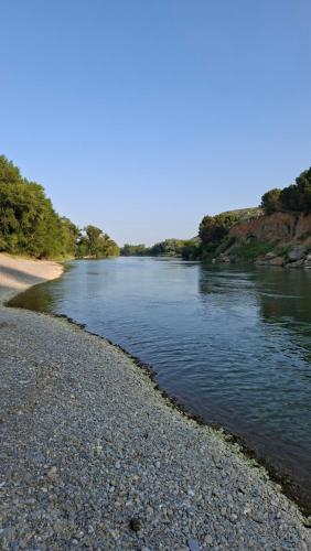 a river with a rocky shore next to a beach at Apartamento rural Las Cañas Esencia de Bardenas in Villafranca