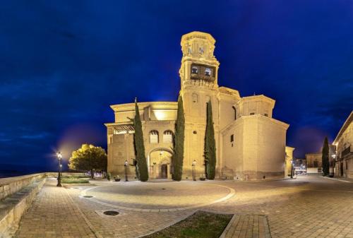 a large building with a clock tower at night at Apartamento rural Las Cañas Esencia de Bardenas in Villafranca